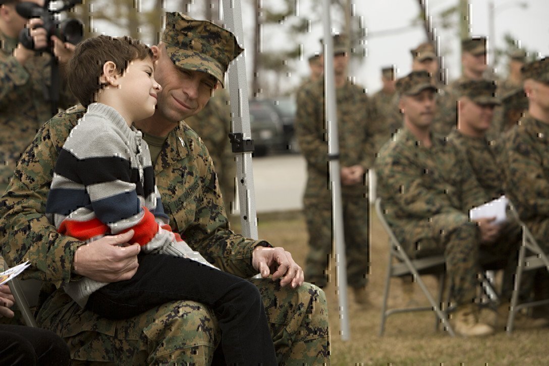 a marine father with his son on his lap