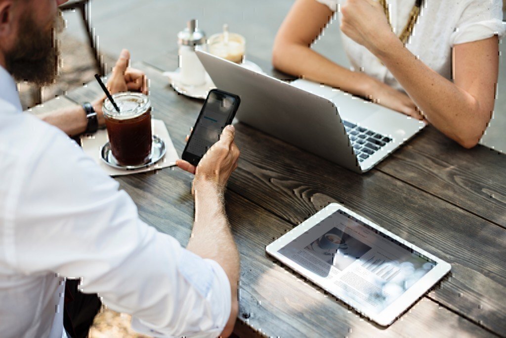 a picture of two people working over a laptop