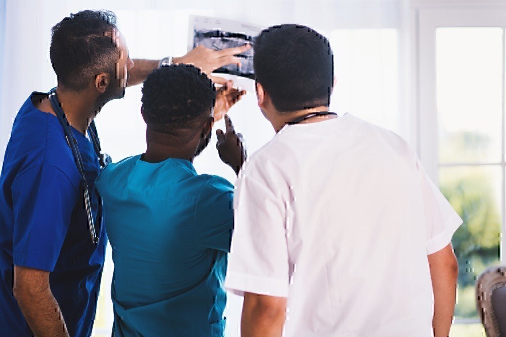 a picture of a few doctors looking at a medical chart