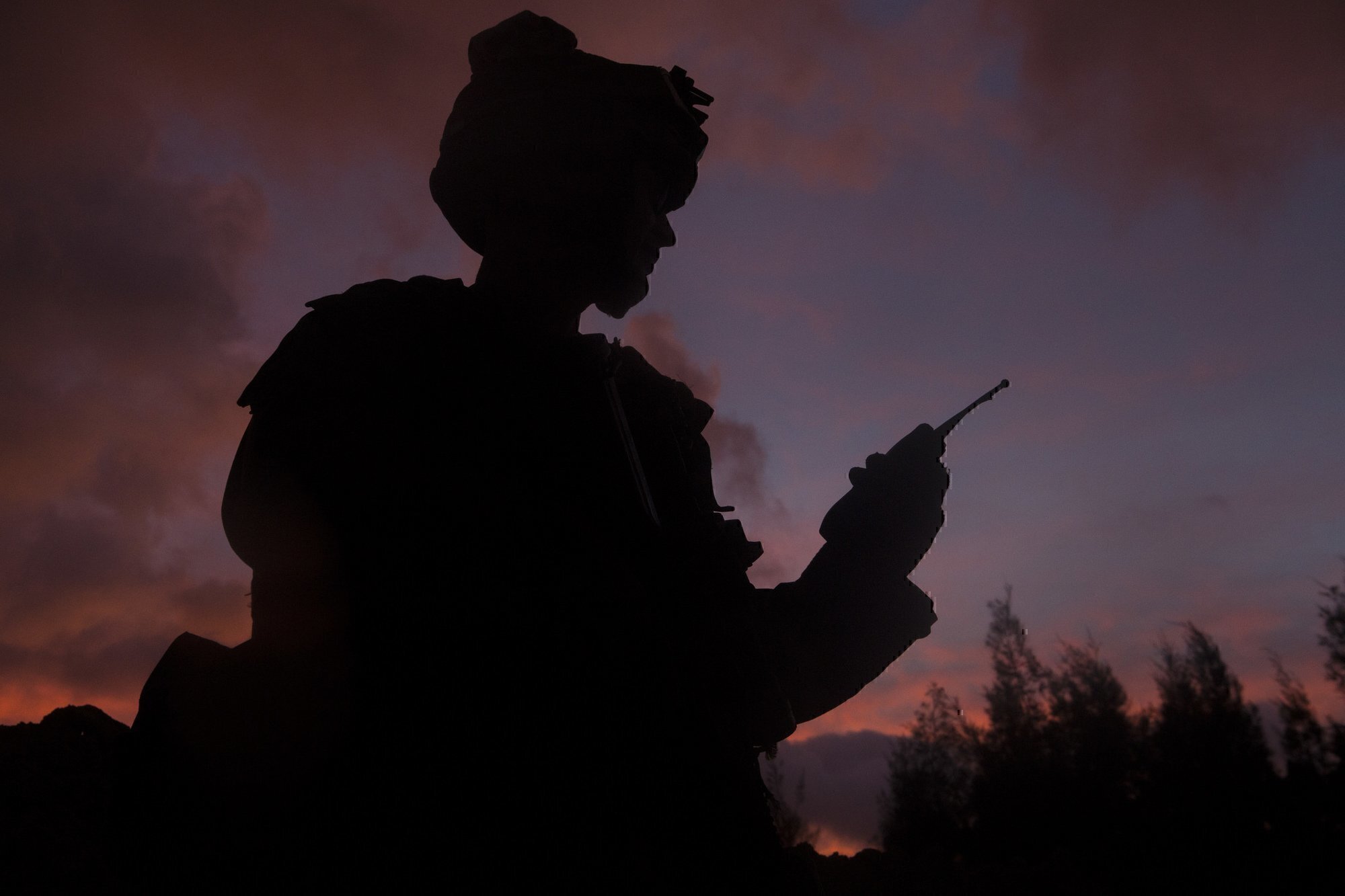 a soldier speaks into a radio, a common practice in IT Jobs