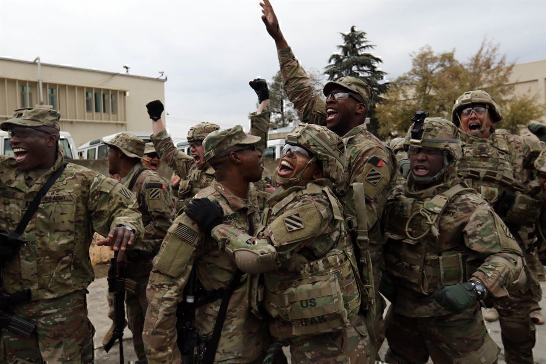 Soldiers gather in a group, cheering