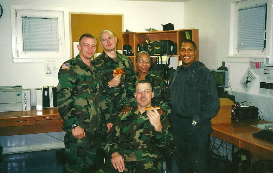 Alarik in uniform with during the military eating pizza with service members. 