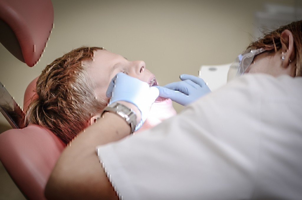 dental hygienist cleans a patient's teeth