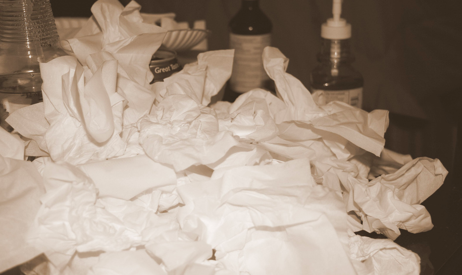 pile of tissues sitting next to a bed