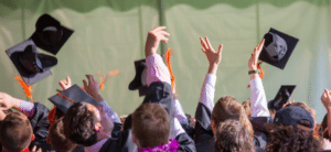 A group of students tosses their graduation caps in the air