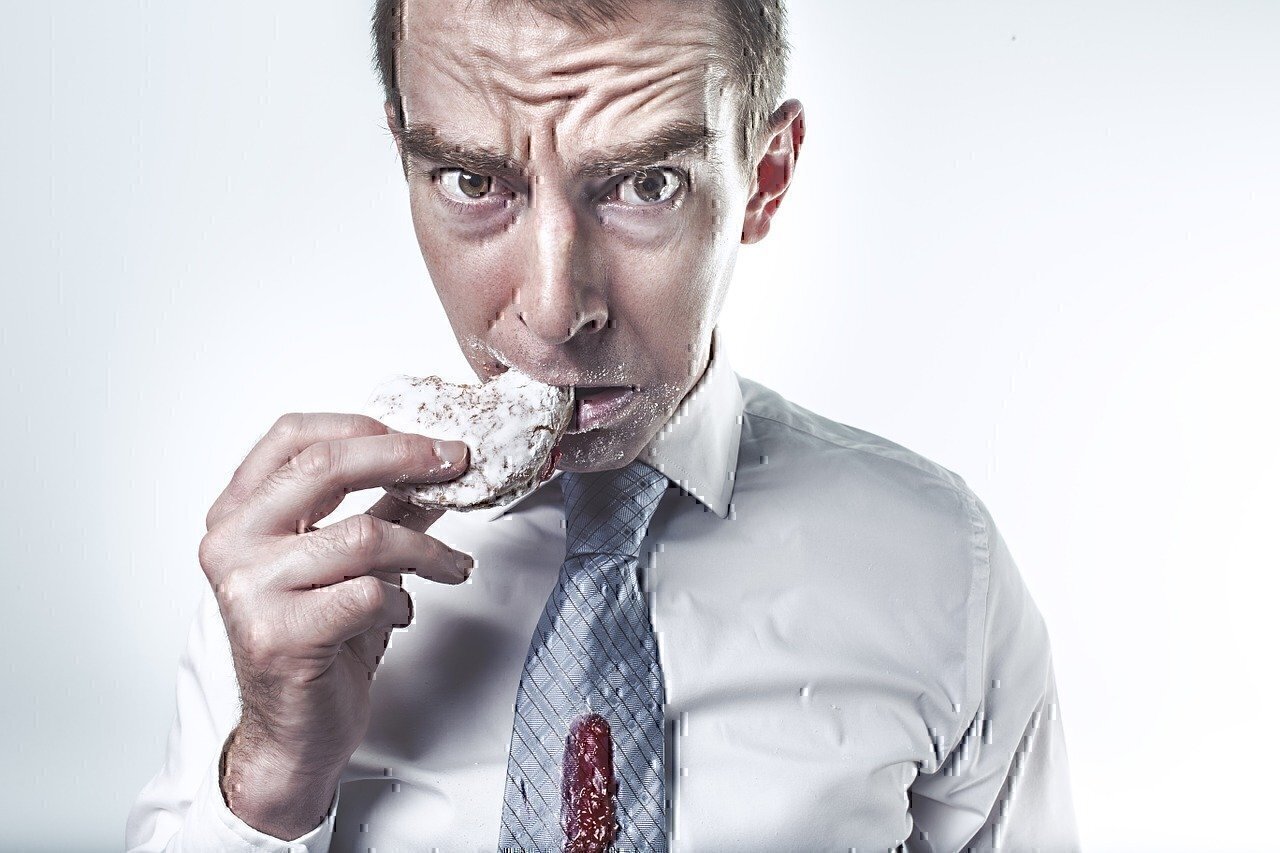 man eating donut spilled on shirt