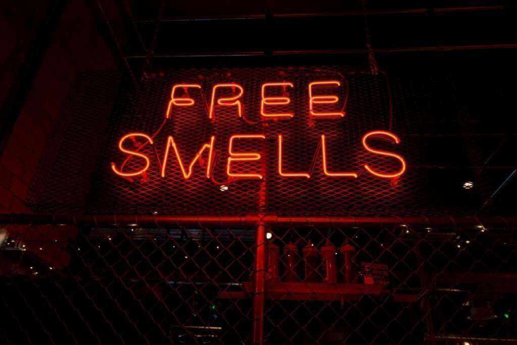 red neon sign that says free smells