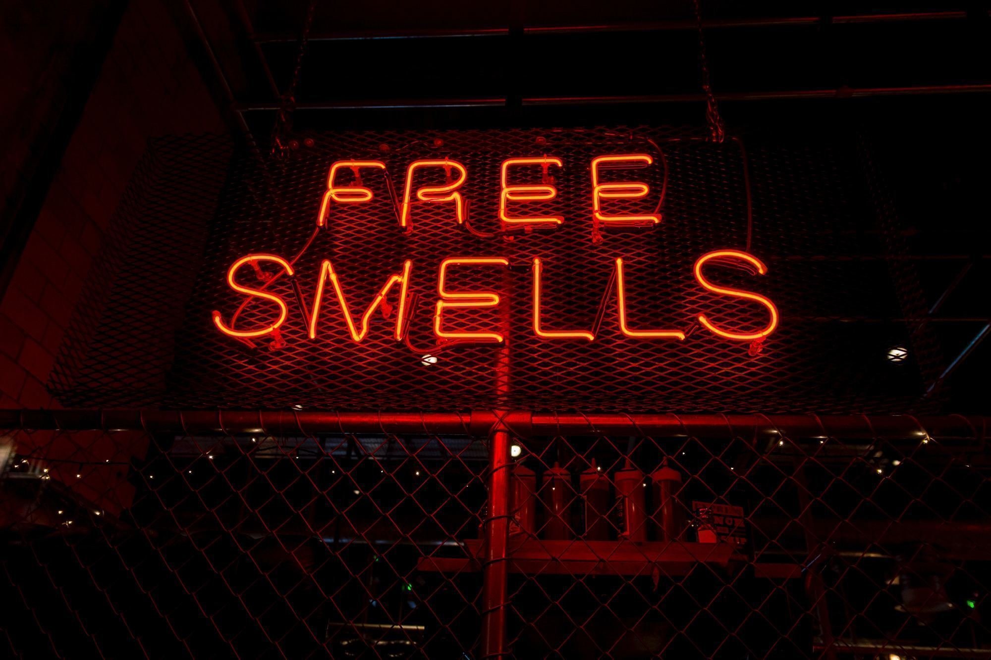 red neon sign that says free smells