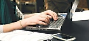 a person typing on a computer at their desk