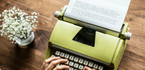 a person's fingers typing on a typewriter