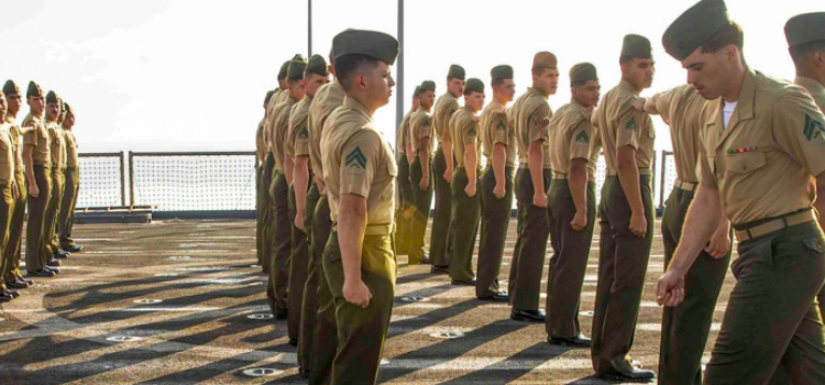 Marines line up on the deck of a ship