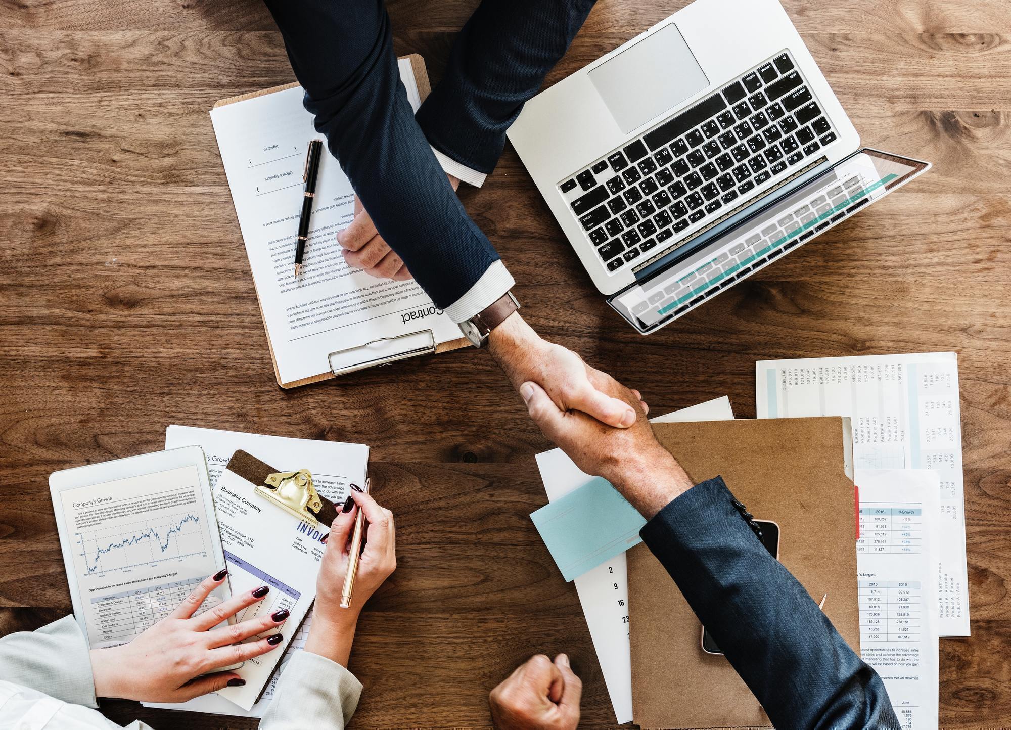 two people shaking hands across a table