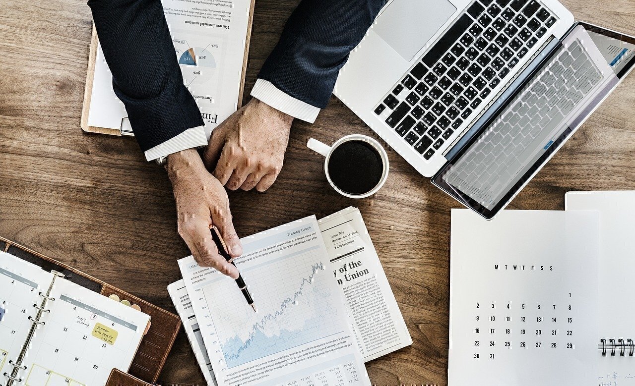 A man points at a graph on a spreadsheet