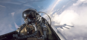a fighter pilot sits in the cockpit during a flight