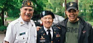 three veterans standing together smiling for a picture