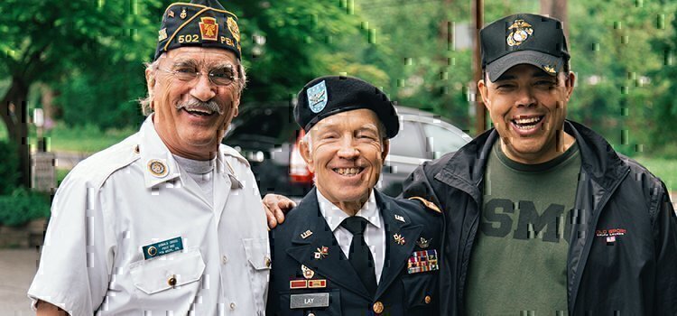 three veterans standing together smiling for a picture