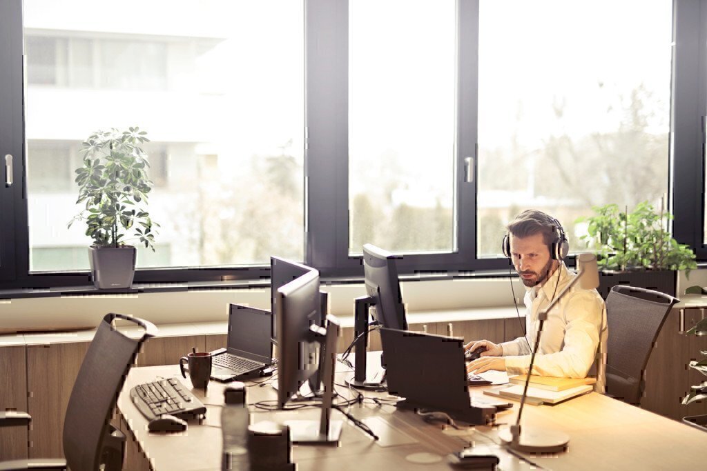 man work on a laptop with headphones on