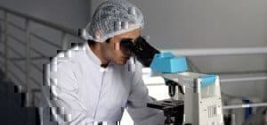 scientist looking down a microscope