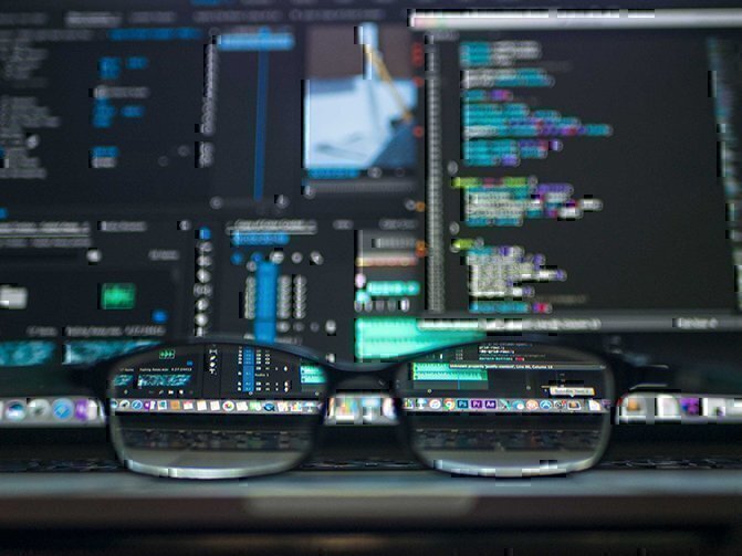 glasses on a table with a screen in the background