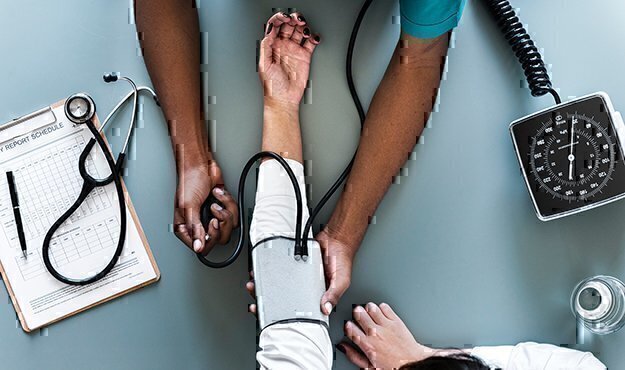 doctor checking a patience pulse and blood pressure