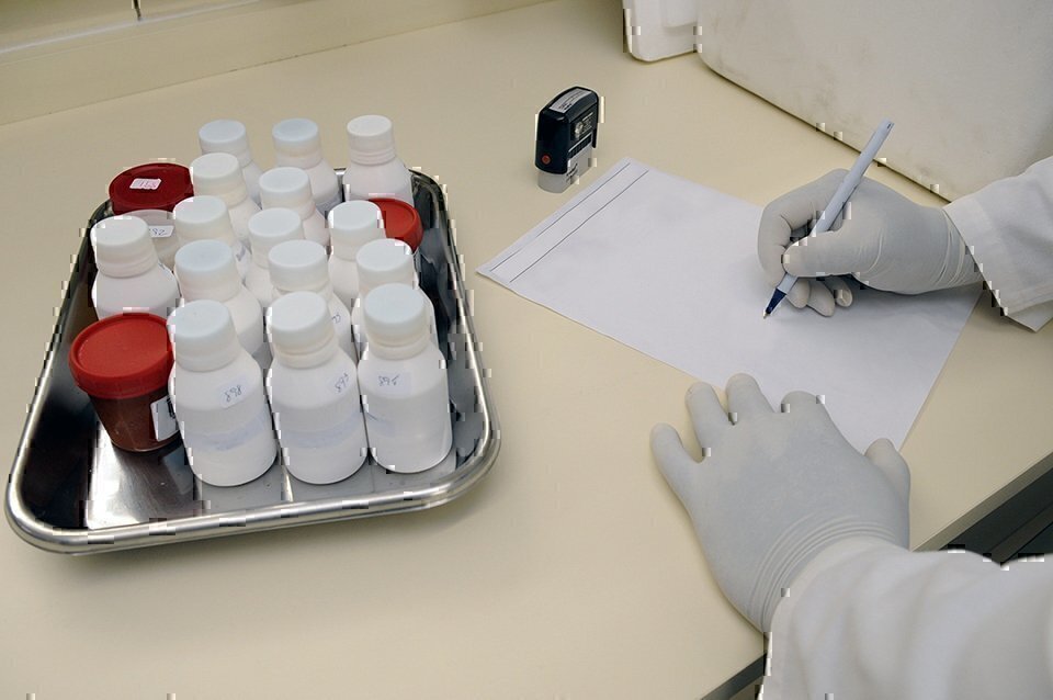 researcher writing down notes from samples on a desk