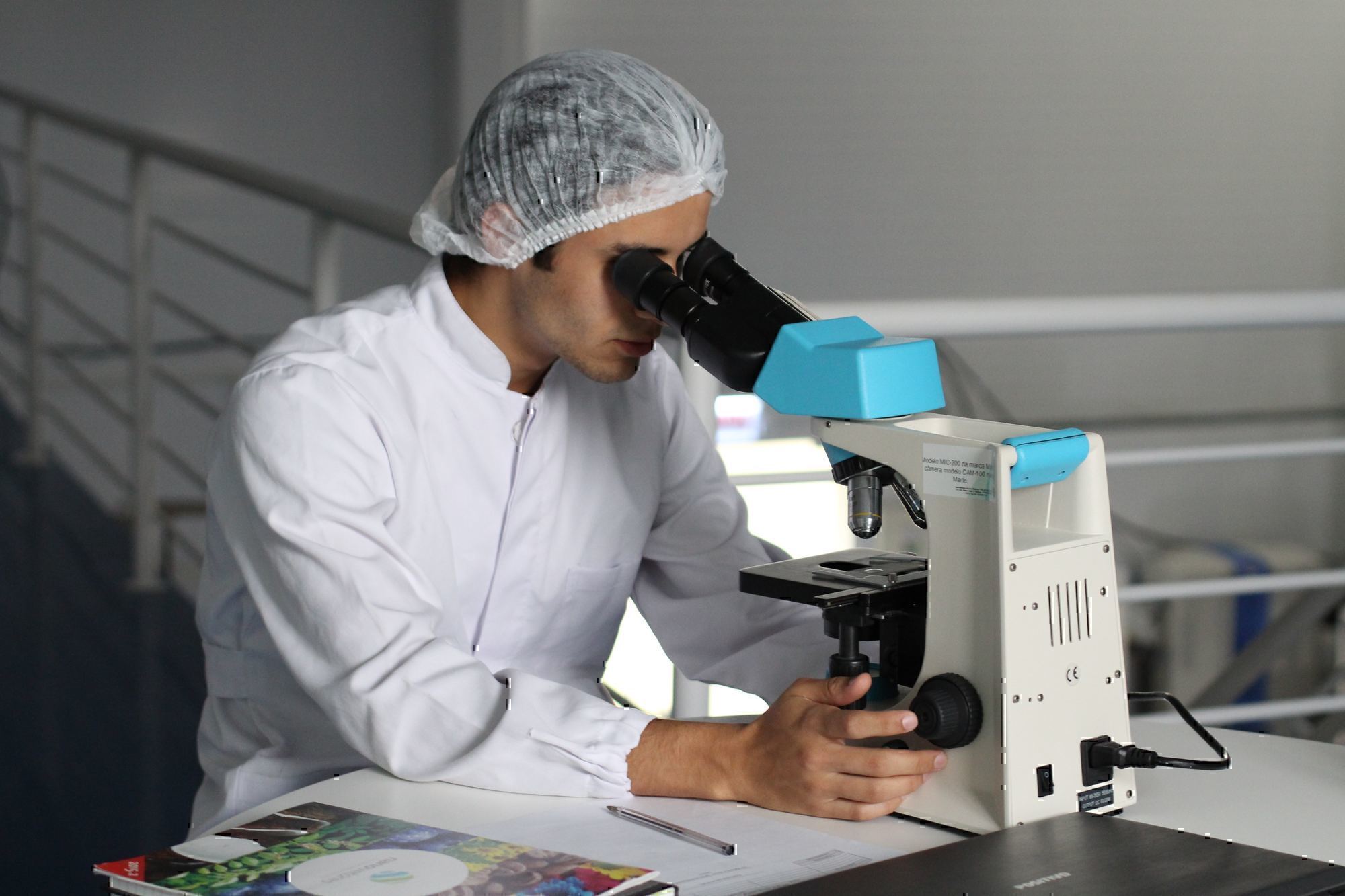 a lab technician looks through a microscope