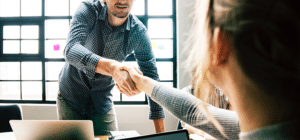 two people shaking hands in an office