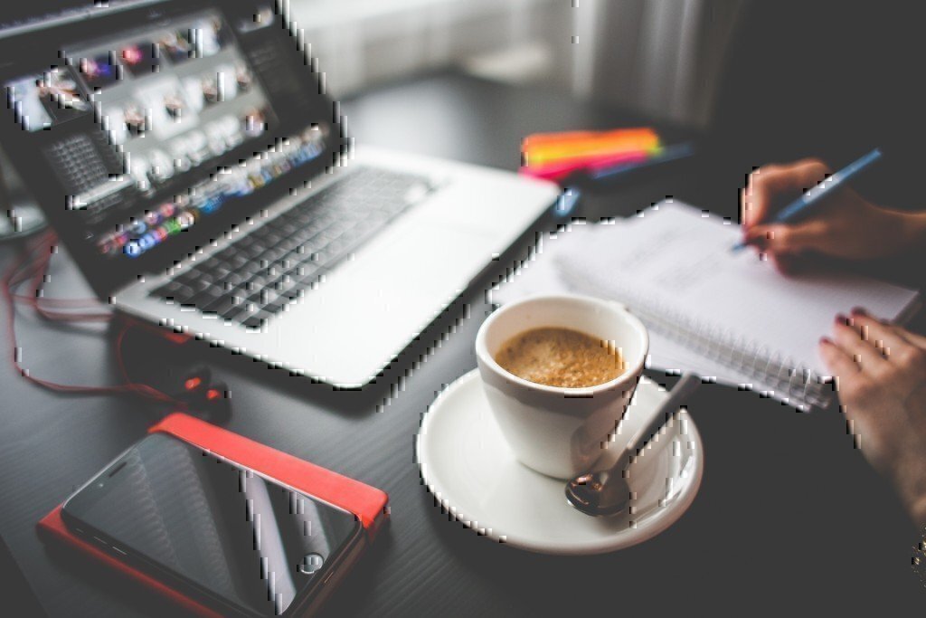 a picture of a coffee, notebook and a laptop