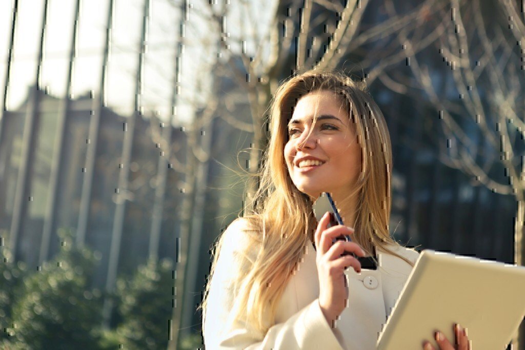 a woman answering the phone and smiling