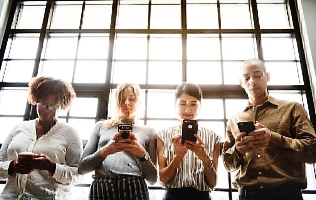 a group of people on phones in a line