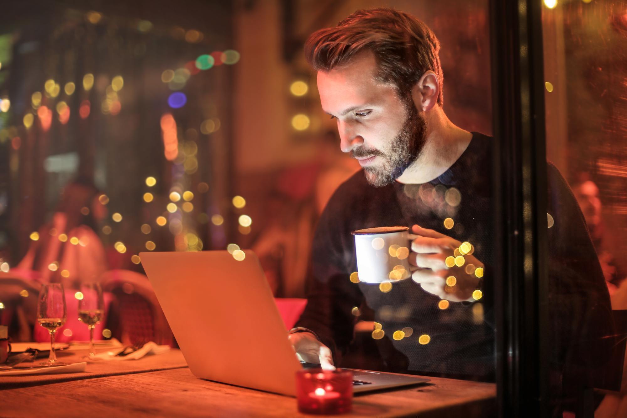 a man drinking coffee on a laptop