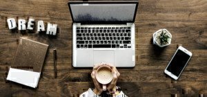 a person with a cup of coffee and a laptop