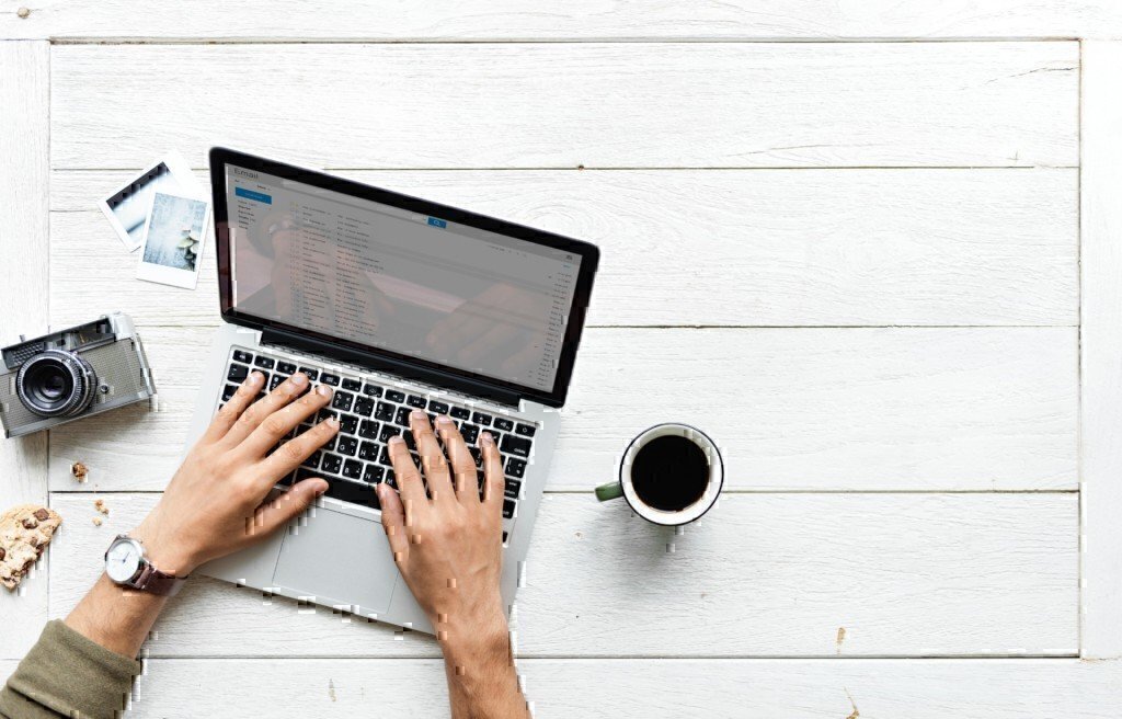 a picture of someone typing on a laptop