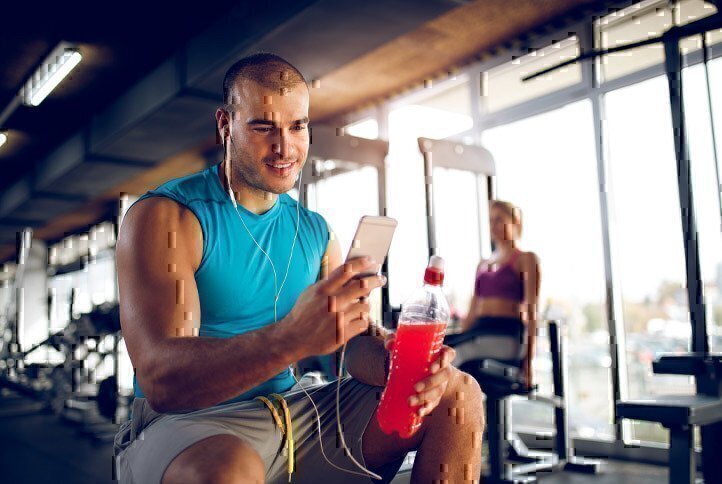 man-in-gym-looking-at-phone