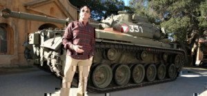 arnold-schwarzenegger-standing-in-front-of-his-tank