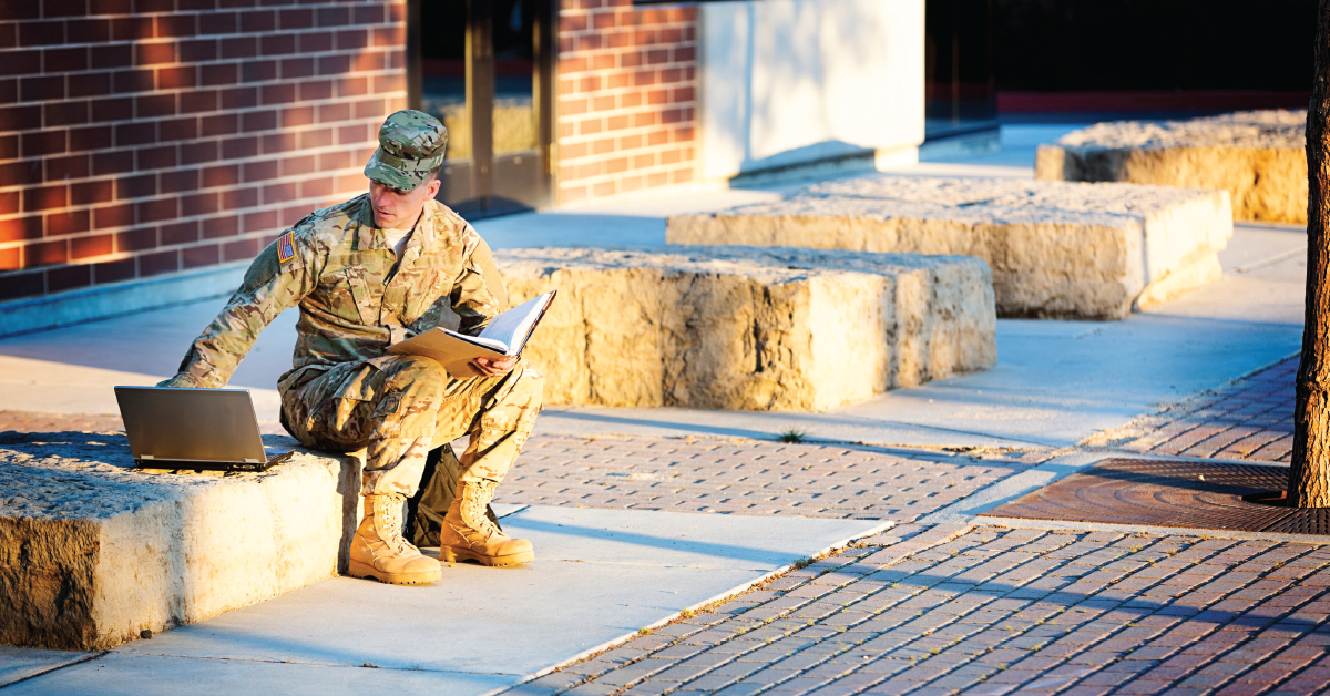 Veteran sitting outside on a bench doing homework at school