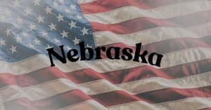Waving American flag with the word 'Nebraska' in bold black letters across the center.