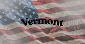 Waving American flag with the word Vermont in bold black letters across the center